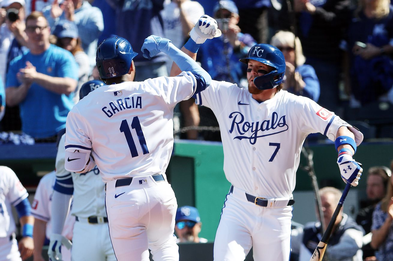 Bobby Witt Jr. #7 of the Kansas City Royals congratulates Maikel Garcia #11 after Garcia hit a solo home run during the 1st inning of the opening day game against the Minnesota Twins at Kauffman Stadium on March 28, 2024 in Kansas City, Missouri.
