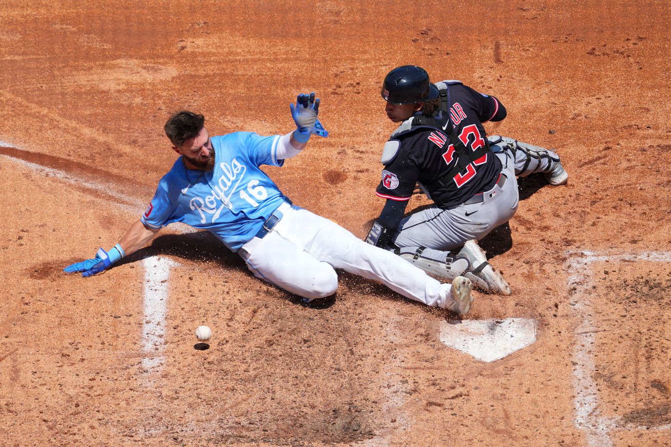 John Rave #16 of the Kansas City Royals slides into home to score against Bo Naylor #23 of the Cleveland Guardians in fourth inning at Kauffman Stadium on July 27, 2025 in Kansas City, Missouri.