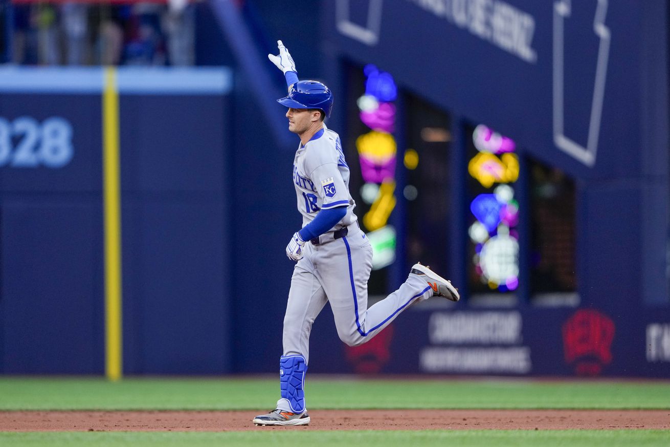 Mike Yastrzemski runs the bases after hitting a home run. He is pointing in the air as he does so.